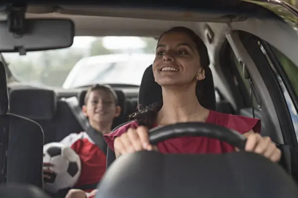 A parent driving a child to football practice